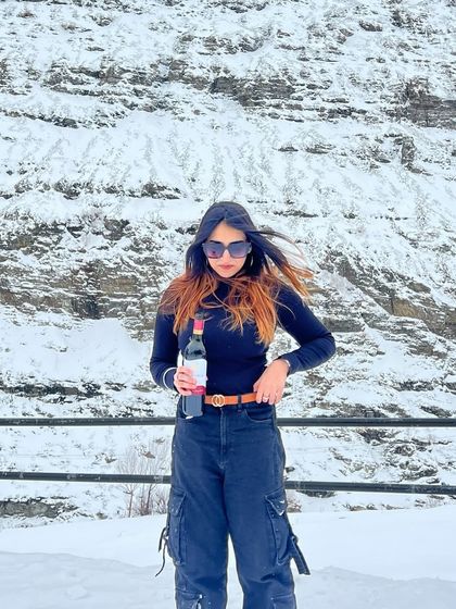 A fun and candid shot in the snow in Sissu, holding a bottle of wine. This shows a more relaxed and playful side of my travel adventures.