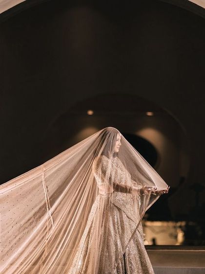 A duplicate of the stunning artistic shot of the bride with her long, flowing veil against a circular architectural feature.