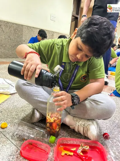 A student carefully pours water into his mixture of fruit peels. This activity teaches precision, patience, and the science behind creating natural bio-fertilizers.