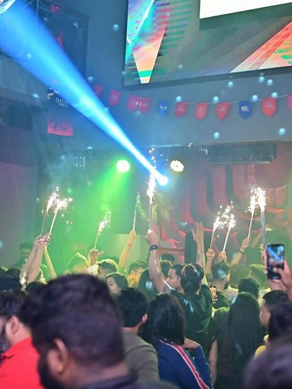 The view from the dance floor at Tipsy Bull. A sea of people, sparklers held high, and a blue spotlight cutting through the haze. Pure magic.