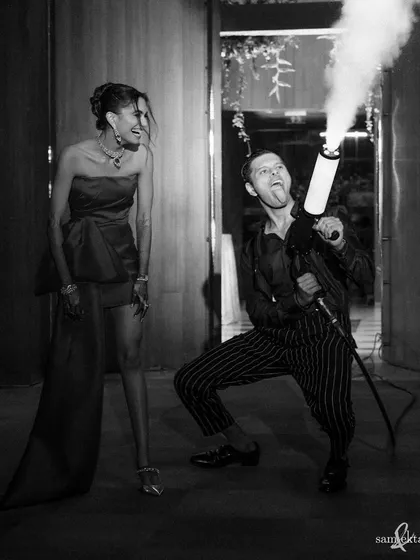 Sid unleashes his crazy side with a smoke gun at the after-party, much to Saumya's amusement. We love capturing the groom's playful personality and the fun of the celebration.