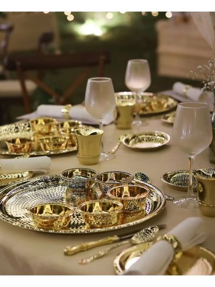 A detailed look at the exquisite hammered brass thalis and katoris used in our traditional Indian sit down service. This opulent tableware is central to creating an authentic and royal dining experience for weddings and cultural celebrations.