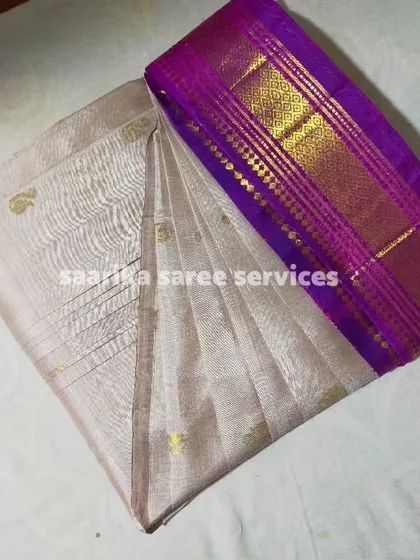 A beautiful off-white tissue saree with a purple border, watermarked with my service name.