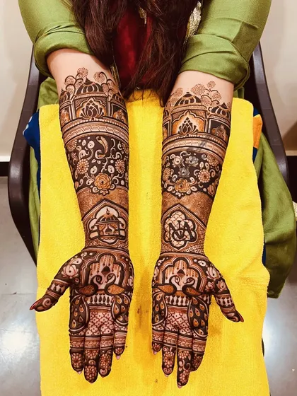 A closer look at a floral and architectural design. The dark, rich stain from our organic henna makes the intricate details of the flowers, peacocks, and domes stand out beautifully.