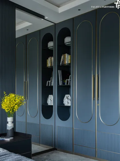 This bedroom design strikes a careful balance, embracing boldness through deep blue surfaces and gold inlay detailing on the custom wardrobe. This approach creates a 'maximalist palette through a minimalist gaze', feeling rich and expressive without overwhelming the senses.