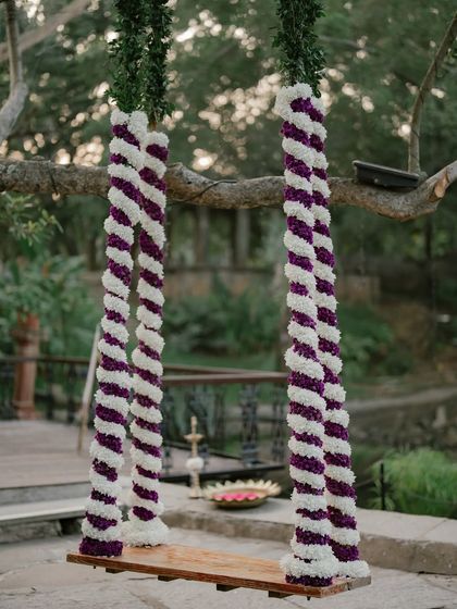 The wedding swing decorated with purple and white flowers, adding a pop of color to the ceremony.