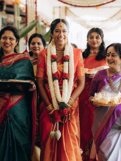 A radiant bride during her temple wedding entrance, surrounded by the women in her family. Her joyful smile says it all.