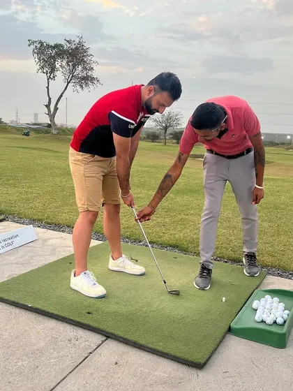 A coach provides hands-on guidance to a new player, adjusting their grip and stance to ensure they develop good habits from the start.