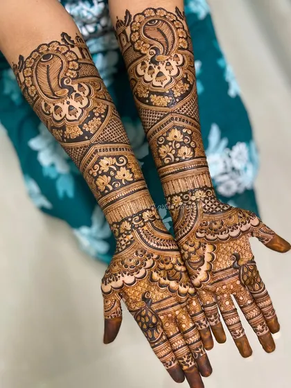 A stunning bridal design with large, bold peacocks on the arms. The intricate feather details and surrounding floral patterns make this a true work of art.