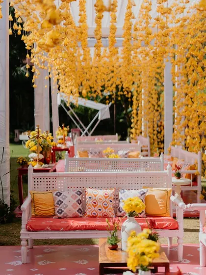 The lounge area at our 'Haldi Holi' party was a sea of yellow. We hung thousands of yellow tassels from the pergola, creating a dreamy, immersive space that looked incredible as the breeze blew through.