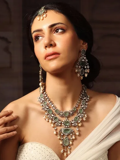 A layered emerald and polki necklace with a matching maang tikka, a complete set for the modern bride who loves tradition.