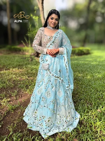 A full-length shot of the blue lehenga in a beautiful outdoor setting.