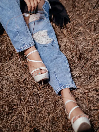 A detail shot of ripped jeans and stylish heels. This focuses on the styling of the shoot and is great for lookbooks or fashion blogs.