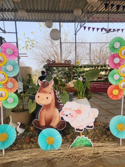 Decorative elements at the farm party, featuring colorful paper pinwheels and cutouts of a horse and sheep. These were used to brighten up the entrance and other areas of the venue.