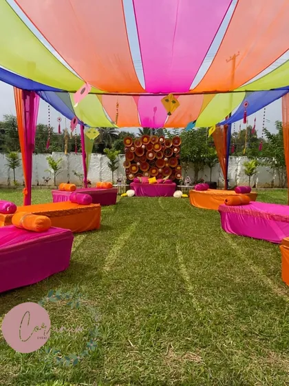 The full layout of a vibrant outdoor Mehendi ceremony, with low seating and colorful drapes creating a relaxed and festive vibe.