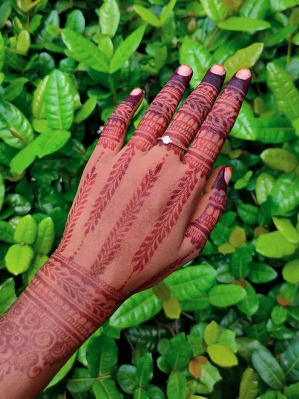 A simple yet striking design featuring parallel leafy vines running down the back of the hand and fingers.