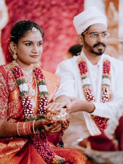 The couple performing a ritual together, their focus on the sacred act that unites them.