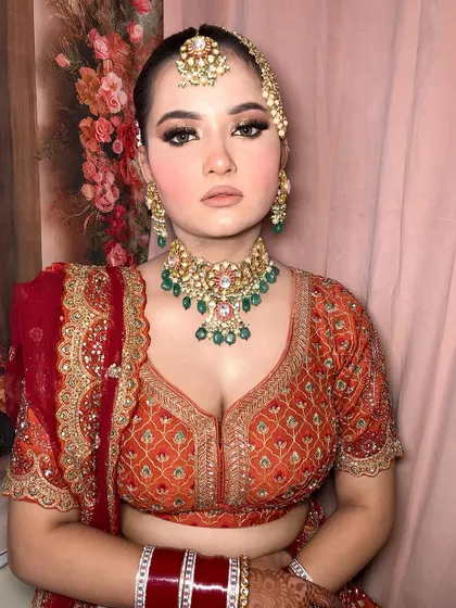 A close-up of the bride's jewelry, showing the choker, maang tikka, and passa.