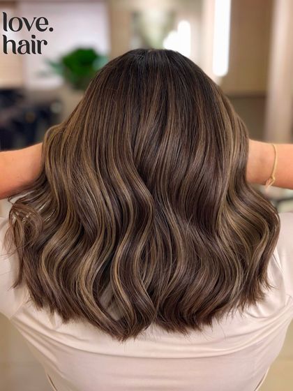 Dreaming of custard vanilla pies. This look was created with a bleach and tone balayage to achieve cooler, ash-brown highlights that contrast beautifully with the darker base.