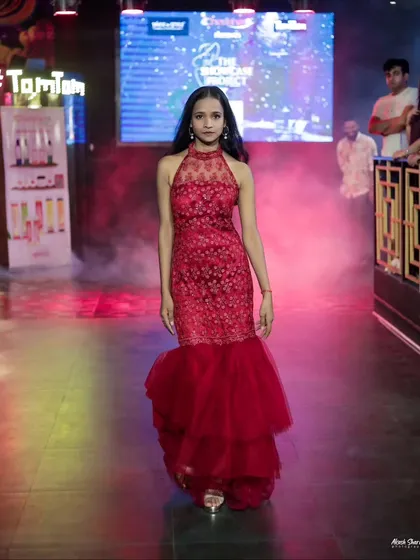 The full runway look of the red gown, showing how the tiered tulle bottom moves as the model walks.