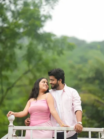 A lovely portrait on a balcony overlooking a green landscape. The couple's gaze towards each other is full of affection, and the natural setting provides a peaceful and romantic atmosphere for their pre-wedding shoot.