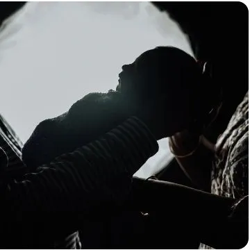 An artistic silhouette focusing on the profile of a newborn being held, highlighting their delicate features.