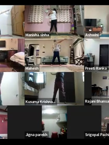Participants practicing a gentle standing warm-up exercise during our early morning online class. We always begin with movements that safely prepare the body for deeper asanas.