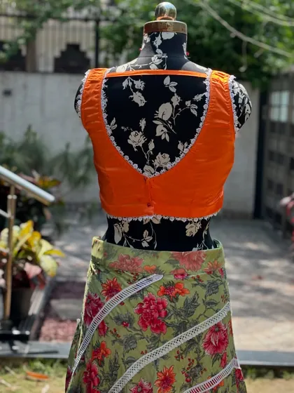 The back of the orange blouse, showing the simple yet elegant design.