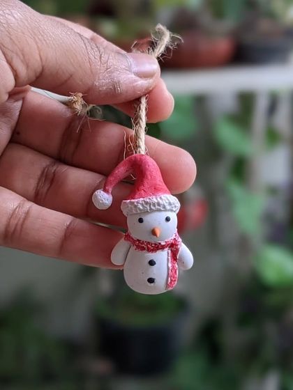 A single snowman ornament, ready to be hung on a Christmas tree. Each one is handmade with love.