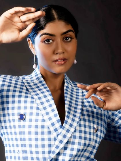 A beautiful close-up in a classic gingham suit. The framing with her hands adds an artistic touch to this elegant black and white style portrait.