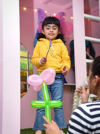 A little fairy with a magic wand receives a flower balloon. It's all about the magical little touches.
