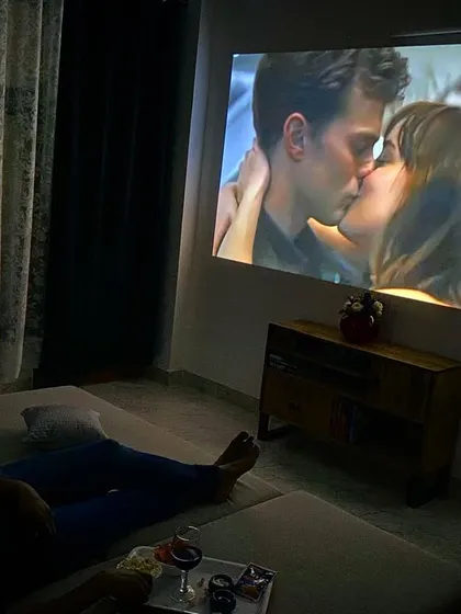 Imagine this: just the two of you, relaxing on a comfy lounger with wine and popcorn, watching your favorite romantic movie on a giant screen. This is the private cinema experience I offer, right in your room.