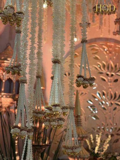 A close-up of the intricate hanging floral chandeliers, showcasing the detailed craftsmanship and the beautiful combination of flowers and bells.