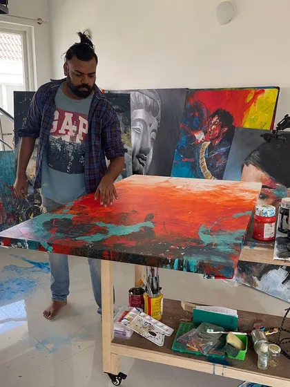 A glimpse into my studio where the magic happens. Here I am working on 'The Uprising', using palette knives and my hands to layer thick acrylics. This is where ideas, colors, and textures come together.