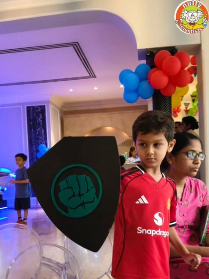 A young hero stands ready with his Hulk-inspired shield, which he created himself during the party. This activity lets kids express their creativity and then use their craft in games.
