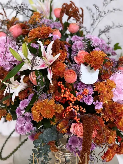 A multitude of enticing colours and classic blooms. This arrangement makes a wonderful statement with the intensely saturated hues of orange, pink, and white from lilies, hydrangeas, and ilex berries.