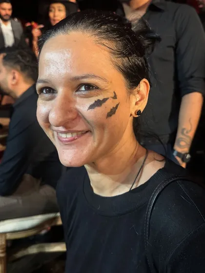 A simple yet classic Halloween look with three bats painted on the cheek. It's a quick and fun way to get into the spooky spirit.