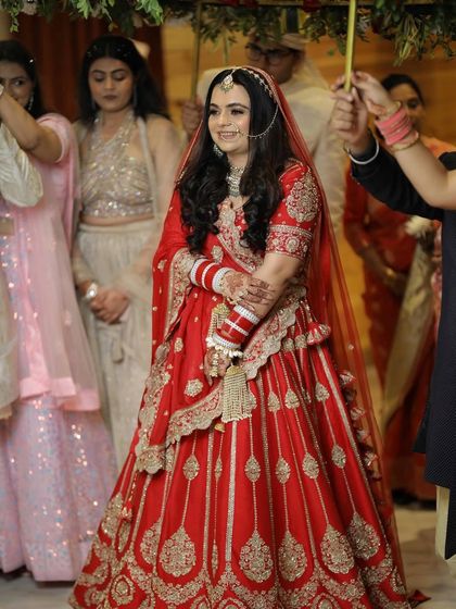 The bride's grand entrance. Tusharika looks absolutely beautiful in a classic red lehenga from Koskii, a timeless choice for her wedding day.