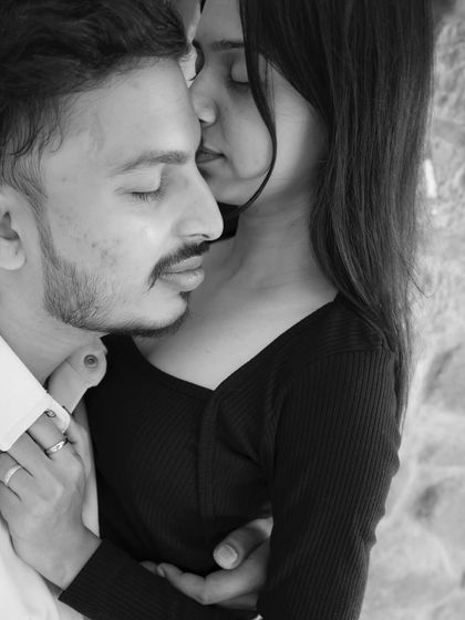 An intimate black and white close-up. This shot focuses on their gentle embrace and the quiet emotion shared between them.