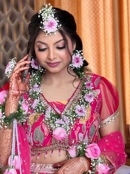 A close-up of the Haldi makeup. The look is fresh and dewy, with soft pink tones that complement the floral jewelry.