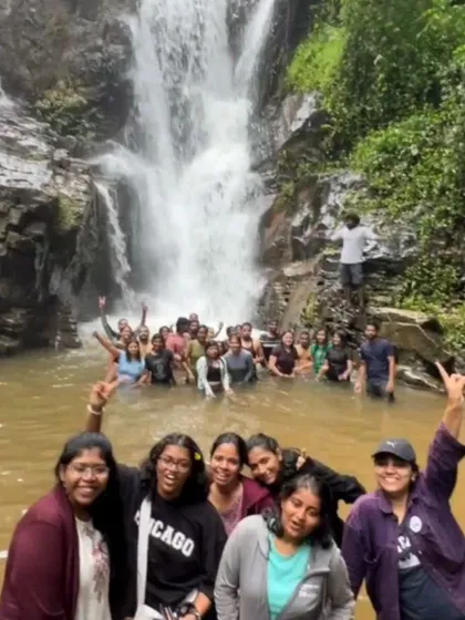 A fun group photo with everyone splashing and enjoying the water at a waterfall near Chikmagalur.