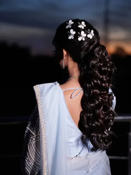 Another angle of the intricate ponytail, showing how the curls and accessories come together to create a romantic and modern bridal hairstyle.