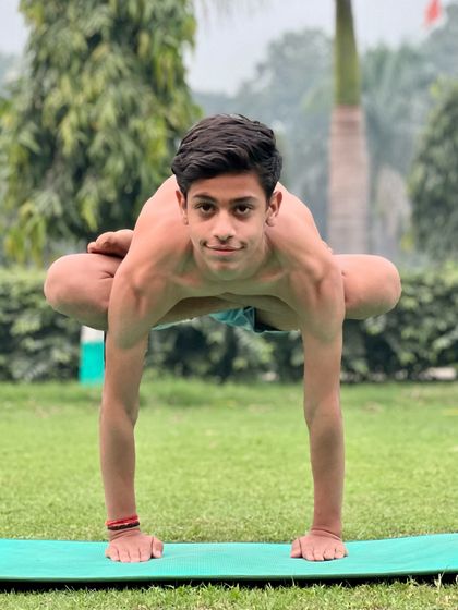 A low arm balance that builds wrist and shoulder strength. The student's calm expression shows his control over the pose.