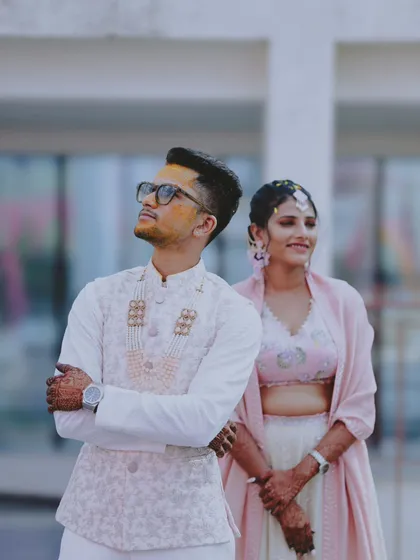A stylish portrait of the groom with his bride slightly out of focus in the background.