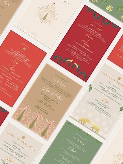 A collection of cards from a timeless and elegant invitation suite. The design uses a warm color palette of red, brown, and cream, with simple yet beautiful motifs like the 'tree of life' and elephants.