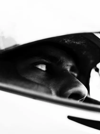 An artistic, high-contrast shot of a driver's eyes in his helmet.