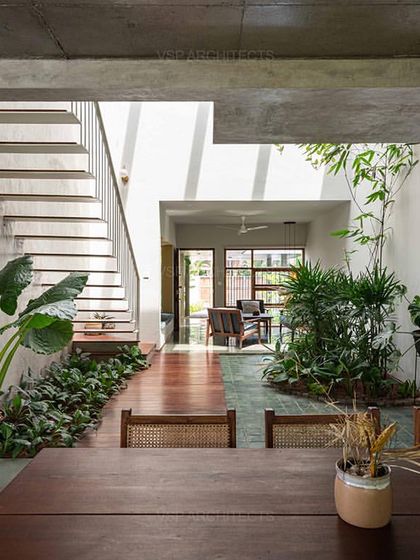 The view from the dining area looks across the internal courtyard, showcasing how the home's layout is organized around natural elements to create a sense of openness.
