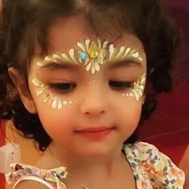Even the littlest guests can enjoy some gentle face painting. This elegant gold and white design on the forehead is delicate, beautiful, and perfect for a little princess.
