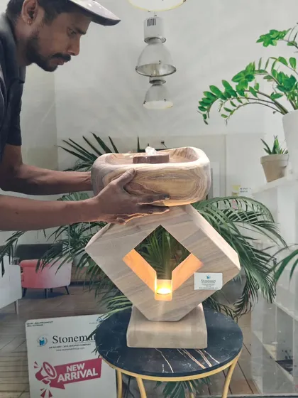 An artisan assembles our modern indoor fountain with a built-in light. This tabletop piece is crafted from beautiful rainbow stone and is lightweight enough for a console table or bedside placement.