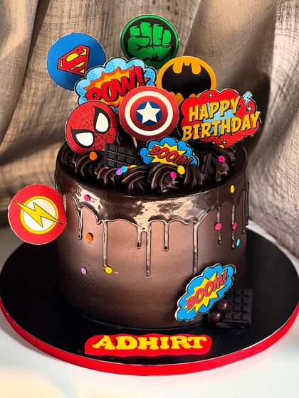 BOOM! BAM! ZAP! This chocolate drip cake is packed with superpowers, featuring logos from Spider-Man, Batman, Superman, and more for a truly marvelous birthday bash.